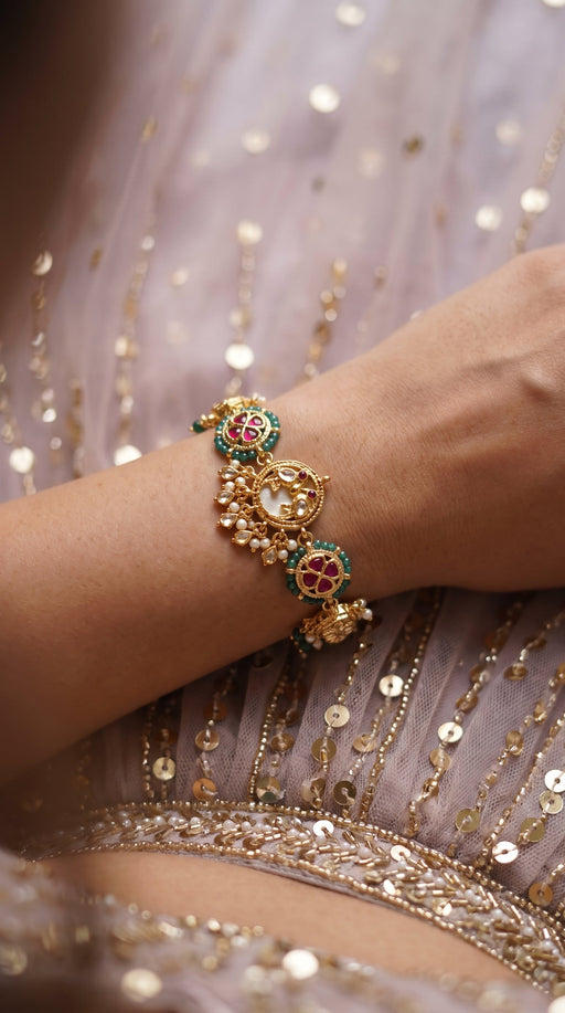 Two red-and-green kundan cuffs that are not the same bracelet