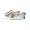 White wedge sandals with pink straps on a white background
