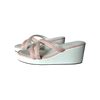 White wedge sandals with pink straps on a white background